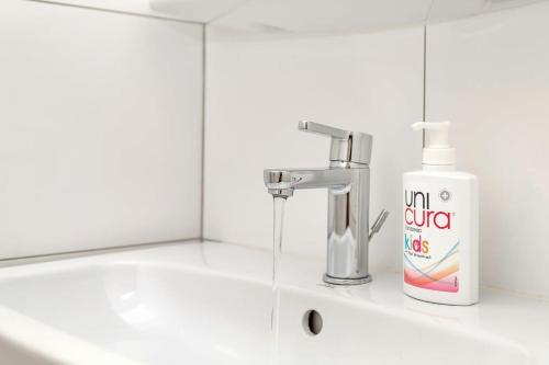 a white bathroom sink with a bottle of toothpaste at Casa Leeward with Pool on the Laguna Marina in Kralendijk