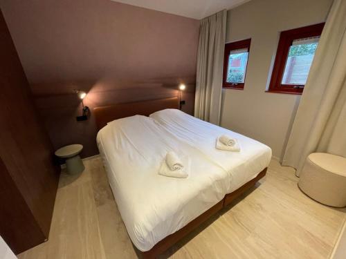 ein Schlafzimmer mit einem Bett mit zwei Handtüchern darauf in der Unterkunft Hello Zeeland - Appartement Duinenburg 10-2 & 3 in Domburg