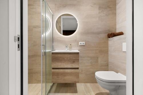 La salle de bains est pourvue de toilettes, d'un lavabo et d'un miroir. dans l'établissement Hello Zeeland - Appartement Duinenburg 10-2 & 3, à Domburg