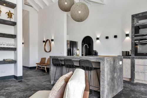 eine Küche mit einer großen Marmortheke und Stühlen in der Unterkunft Costa de la Luz on the water of the Laguna Marina in Kralendijk