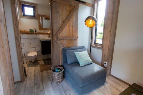 ein Wohnzimmer mit einem Stuhl und ein Badezimmer in der Unterkunft Kas Palulu II a Lovely Tiny House with Jacuzzi in Kralendijk