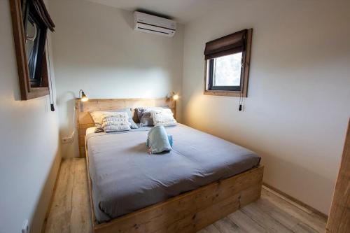 Schlafzimmer mit einem Bett mit einem Holzrahmen und einem Fenster in der Unterkunft Kas Palulu II a Lovely Tiny House with Jacuzzi in Kralendijk