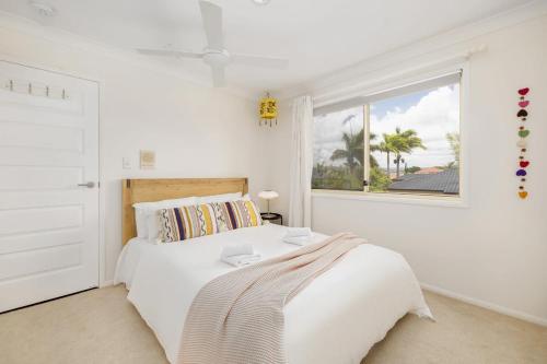 a white bedroom with a bed and a window at Pool Sauna Cinema Office Room 4BR Spacious house in Gold Coast