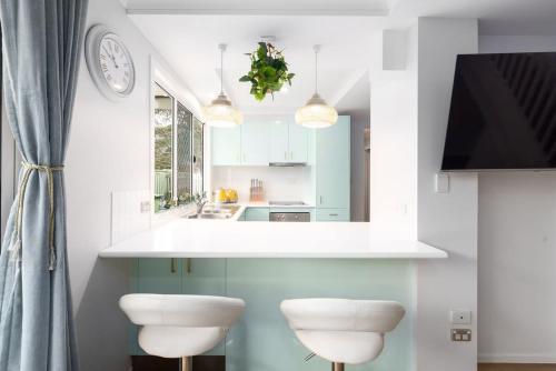 a kitchen with two stools in front of a counter at Serene Southport Getaway Walk to Beach Shops in Gold Coast