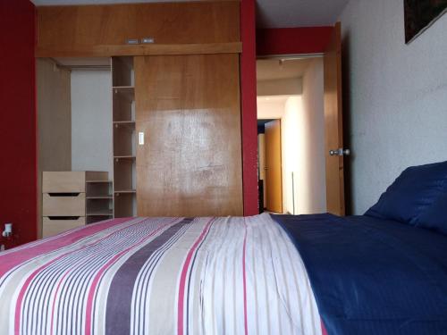 1 dormitorio con 1 cama y puerta de madera en Llegaste a casa almendros, en Santa Cruz Tecamac