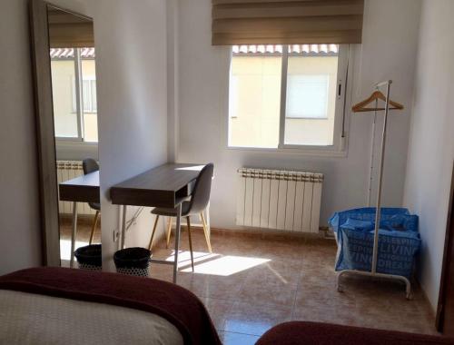 a bedroom with a desk and a table in a room at Pirineo Aragonés. Casa La Paz in Sabiñánigo