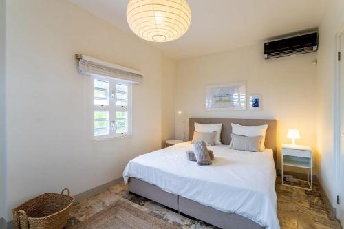 a bedroom with a large white bed in a room at Kas Dive-In with Private Pool on the Laguna Marina in Kralendijk
