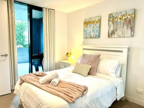 a bedroom with a bed with a blanket on it at Chic 1BR Apt Urban Retreat Pool Parking Gym in Box Hill