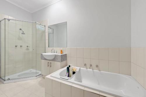 a bathroom with a tub and a sink and a shower at 3BR Townhouse 7km to Chadstone in Chadstone