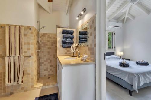 a bathroom with a bed and a sink in a room at Kas Jacco in Laguna Marina in Kralendijk