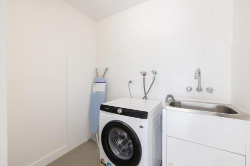 cocina con lavadora y fregadero en Renov Peaceful 3BR Morningside Gem: Cozy Retreat en Brisbane