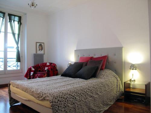 パリにあるAppartement la Bruyere St George CityCosyのベッドルーム1室(赤と黒の枕が付くベッド1台付)