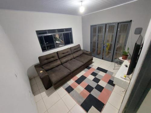 a living room with a couch and a television at Quarto disponível para temporada da Agrishow in Ribeirão Preto