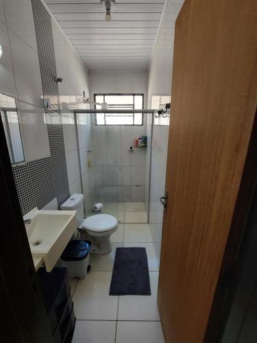 a bathroom with a toilet and a sink and a shower at Quarto disponível para temporada da Agrishow in Ribeirão Preto