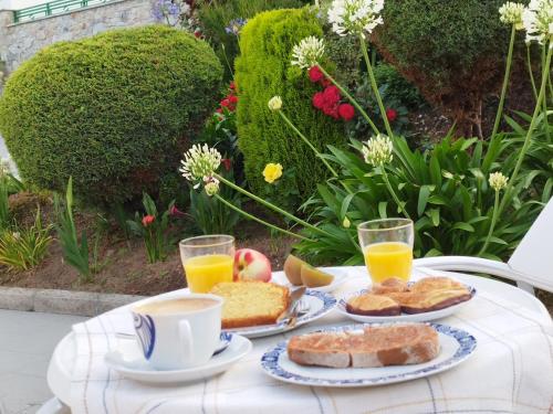 a table with a breakfast of bread and orange juice at Complexo Alameda in Viveiro