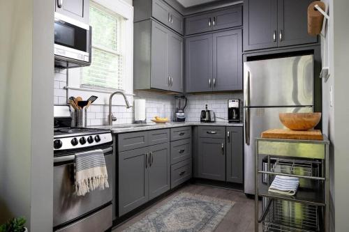 a kitchen with gray cabinets and stainless steel appliances at Prospect in Atlanta