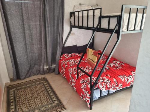 een kleine slaapkamer met een stapelbed en een tapijt bij Résidence tafoult imi ouadar in Agadir nʼ Aït Sa