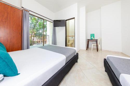 a hotel room with two beds and a window at Hotel Balcones 70 Laureles in Medellín