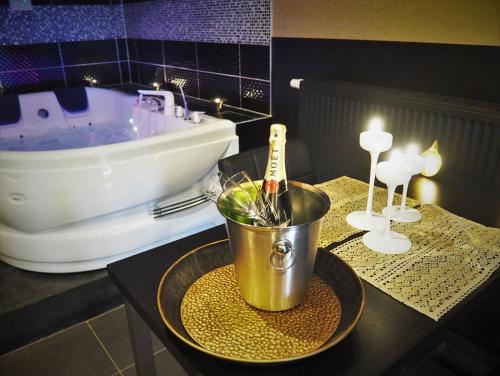 ein Badezimmer mit einer Badewanne und einem Tisch mit einem Eimer in der Unterkunft Symbiose hotel in Charleroi
