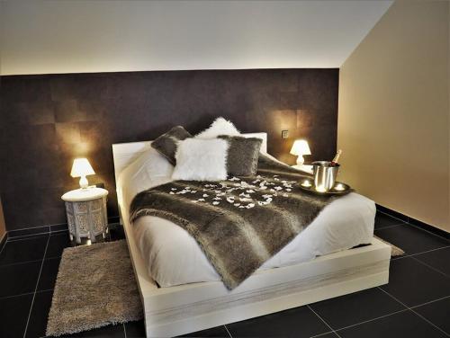 a bedroom with a bed with a black and white blanket at Symbiose hotel in Charleroi