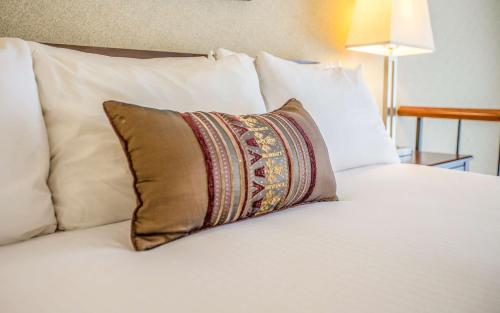 a pillow sitting on top of a bed with white pillows at Hotel 116, A Coast Hotel Bellevue in Bellevue
