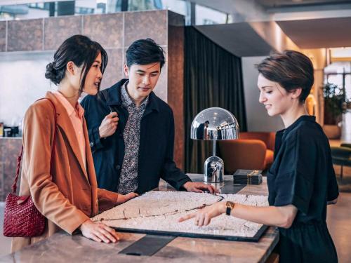 a group of three people looking at a map at Pullman Paris Centre - Bercy in Paris