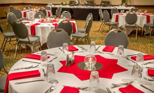 a group of tables with red napkins and silverware at Hotel 116, A Coast Hotel Bellevue in Bellevue