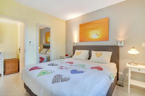 um quarto com uma grande cama branca com almofadas coloridas em Port Bonaire Oasis A701 with Sea View em Kralendijk