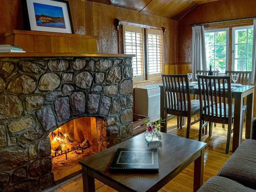 sala de estar con chimenea de piedra y mesa en Tekarra Lodge, en Jasper