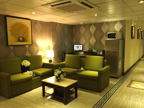 香港にあるカリフォルニア ホテルの緑のソファとテーブルが備わる待合室