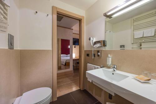 ein Badezimmer mit einem Waschbecken, einem WC und einem Spiegel in der Unterkunft Best Western Hotel Armando in Verona