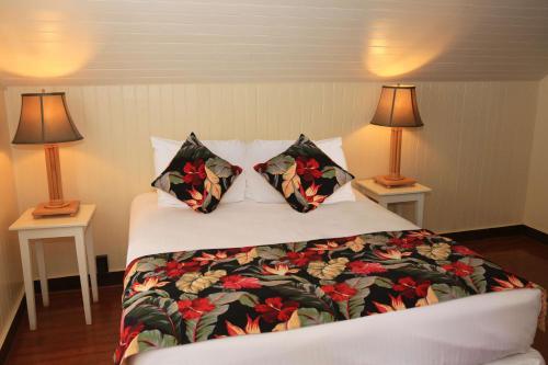 a bed in a hotel room with two lamps at Waimea Plantation Cottages, a Coast Resort in Waimea