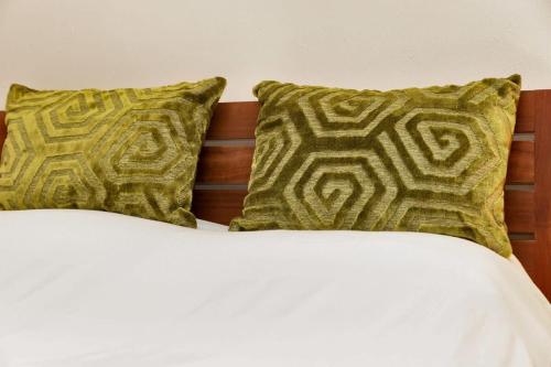 een bed met twee groene kussens erop bij Lac Bay Casita 5 in Kralendijk