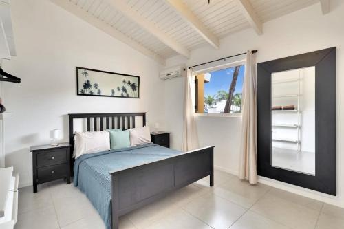 - une chambre avec un lit et une grande fenêtre dans l'établissement Kas Kontentu in Caribbean Court, à Kralendijk