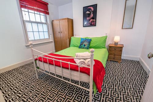 ein kleines Schlafzimmer mit einem grünen Bett in einem Zimmer in der Unterkunft Central 3-Bedroom Townhouse with Patio in Brighton in Brighton & Hove