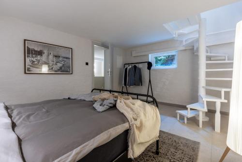 a bedroom with a bed and a spiral staircase at Monciak Comfort - Alejki in Sopot