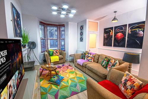 a living room with a couch and a tv at Stylish Super Central Modern Townhouse Retreat in Brighton & Hove