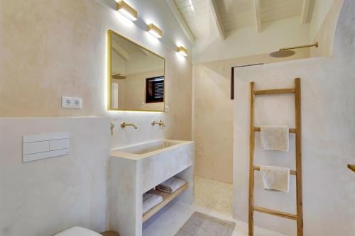 ein Badezimmer mit Waschbecken und Spiegel in der Unterkunft Coral Laguna in Laguna Marina in Kralendijk