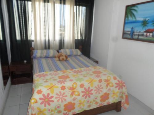 Un dormitorio con una cama con un osito de peluche encima. en Jaqueira Home Service, en Recife