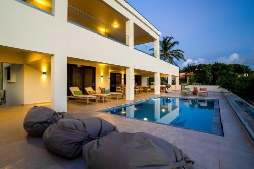 a house with a swimming pool in front of a house at Tres Ojos in Sabadeco in Kralendijk