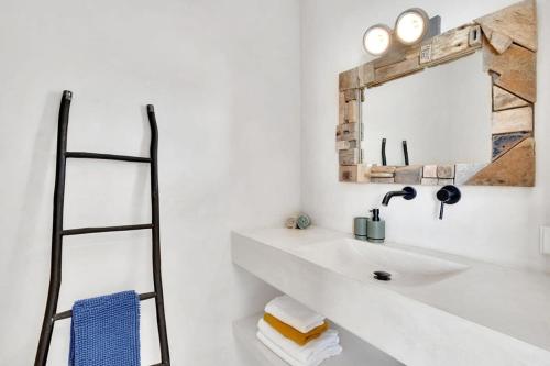uma casa de banho branca com um lavatório e um espelho em Kas Bèrde with stunning views em Kralendijk
