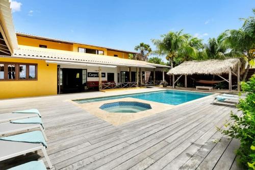 a villa with a swimming pool and a house at Villa Kromboon with an amazing sea view in Kralendijk
