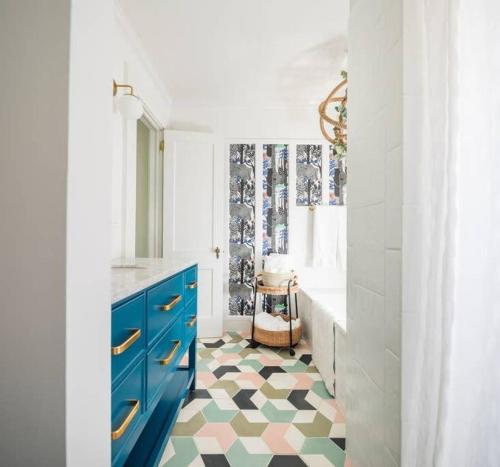 Un baño con armarios azules y suelo a cuadros. en Jungalow Bungalow, en Atlanta