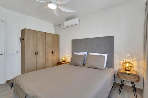 a bedroom with a large white bed with two lamps at Liv Inn Bonaire with Pool and Nice Cooling Winds in Kralendijk