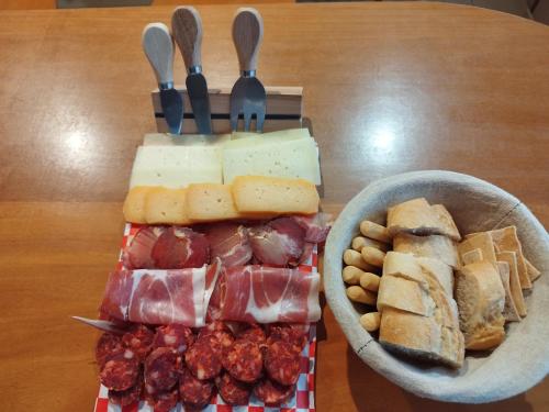 a table with a bowl of meat and cheese and a bowl of nuts at Complexo Alameda in Viveiro