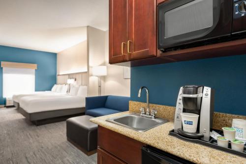 a kitchen with a sink and a bed in a room at Holiday Inn Express Hotel & Suites McDonough by IHG in McDonough