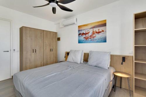 1 dormitorio con 1 cama grande y ventilador de techo en Kas Ariba with pool and Laguna Marina View, en Kralendijk
