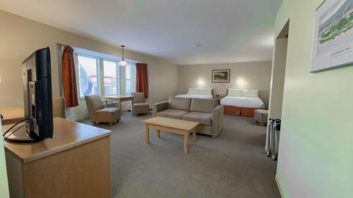 pokój hotelowy z łóżkiem i salonem w obiekcie Eldorado, a Coast Hotel w mieście Dawson City