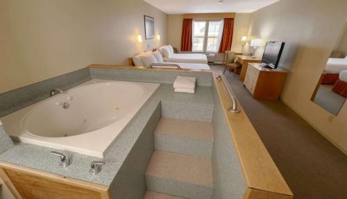 ein großes Bad mit Badewanne in einem Hotelzimmer in der Unterkunft Eldorado, a Coast Hotel in Dawson City