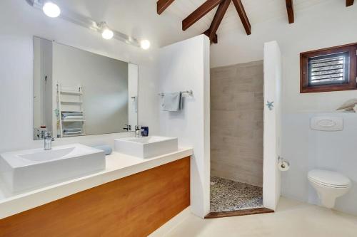 a bathroom with two sinks and a mirror at Casa Magnolia Communal Pool and Outdoor Shower in Kralendijk